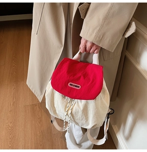 Detail of red and cream nylon backpack with drawstrings and YOU JI BEAR logo label