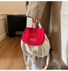 Detail of red nylon backpack with drawstring closure and You Ji Bear logo branding