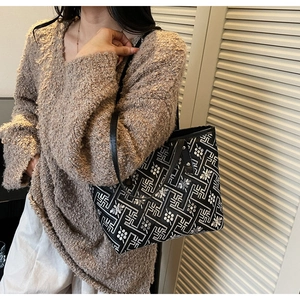Detail of checkered tote bag with ethnic embroidery and slim leather straps