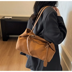 Detail of caramel suede tote bag featuring adjustable shoulder strap and premium texture
