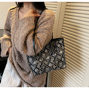 Detail of floral canvas tote bag with black leather straps on a casual model outfit
