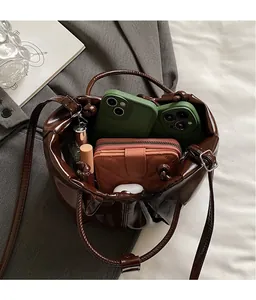 Deep brown bucket bag showing interior storage for phone, wallet and accessories