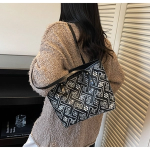 Detail of checkered tote bag with ethnic embroidery patterns on soft canvas fabric