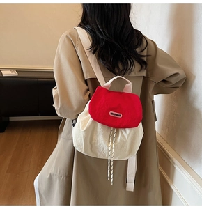 Detail of red and cream nylon backpack with drawstring closure and brand label