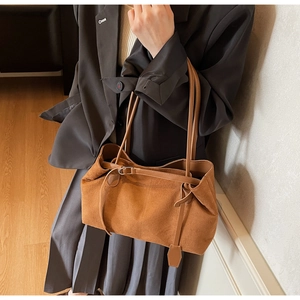 Detail of vintage brown suede tote bag with decorative straps and metal buckles for women