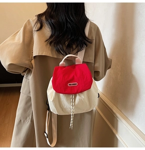 Detail of red and cream nylon backpack featuring drawstring closure and flap design