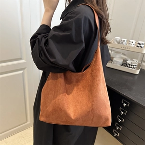 Minimalist brown suede tote bag with wide shoulder strap in a retro spacious design