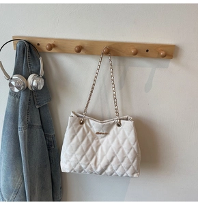 Grand sac cabas matelassé blanc avec bandoulière chaîne sur patères en bois