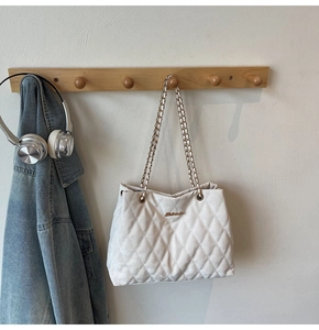 Détail du sac cabas matelassé blanc avec bandoulière chaîne dorée et logo en métal