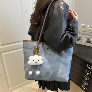 Sac cabas en denim bleu clair avec lanières en cuir marron et breloque nuage doux