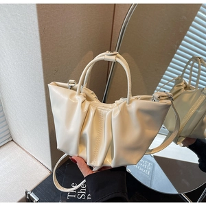 Detailed view of the creamy white pleated cloud bag texture and silver metal hardware