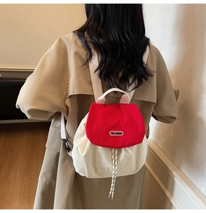 Rear view of a model wearing the cream and red nylon backpack with pink straps