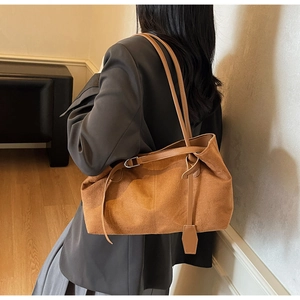 Brown suede tote bag on model showing large capacity and minimalist design