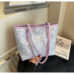 Detail of lavender tote bag featuring intricate jacquard patterns and silver rivet hardware