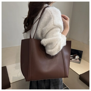 Brown vintage large tote bag with vertical stripes shown on shoulder for daily commute