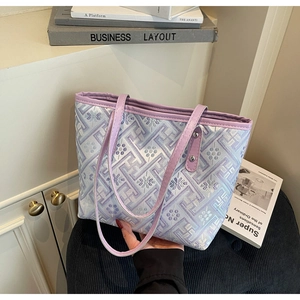 Detail view of jacquard patterned tote bag with lavender faux leather handles and rivets