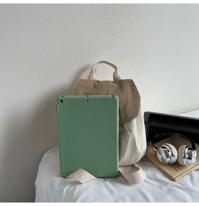 Detail of nylon backpack storage capacity showing tablet fit in beige and brown pockets