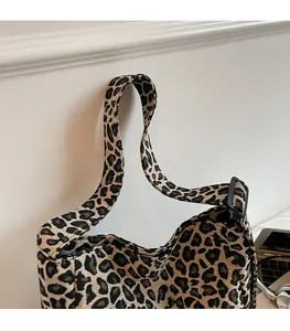 Detail of adjustable shoulder strap and leopard print fabric on a stylish tote bag