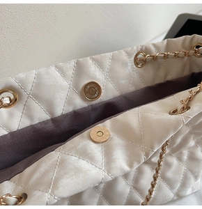 Détail du sac matelassé blanc crème avec fermoir magnétique doré et bandoulière