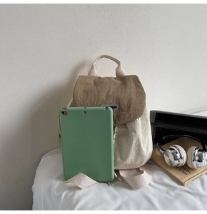 Detail of minimalist nylon backpack showing large capacity with laptop and tech accessories
