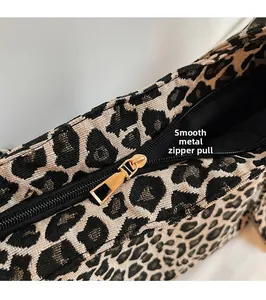 Detail of premium gold metal zipper and smooth leopard print fabric texture on tote