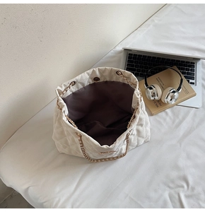 Intérieur spacieux du sac matelassé crème avec fermeture aimantée et poche interne
