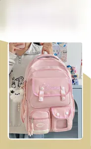 Detailed view of pink school backpack with multiple pockets and cute plush star charm