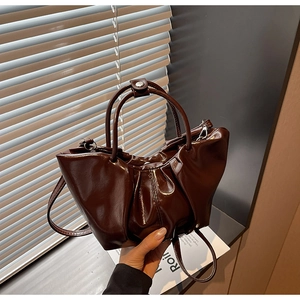Nahaufnahme der dunkelbraunen, glänzenden Wolken-Tasche mit Falten-Design und Reißverschluss