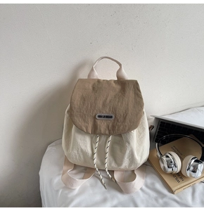 Detail of contrast fabric backpack with drawstring closure and brand label on front