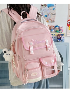 Close-up of pink nylon backpack featuring functional pockets and a cute bear charm