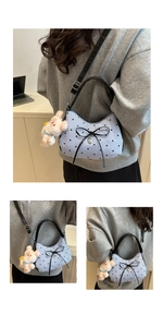 Détail du sac à rayures bleues avec nœud noir et breloque lapin en peluche rose