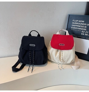 Detail of minimalist nylon mini backpacks in black and red-white with drawstring closure