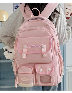 Pink multi-pocket backpack detail with adjustable buckles and cute plush bear charm