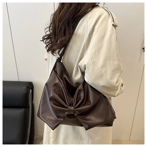 Dettaglio di una borsa hobo in pelle PU marrone scuro con decorazione a fiocco