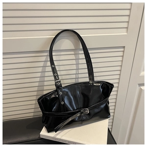 Detailed view of black high-gloss shoulder bag with stylish buckle and silver metal rings