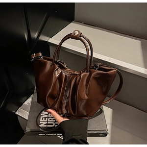 Detailansicht der dunkelbraunen Wolken-Handtasche mit glänzender Faltenstruktur
