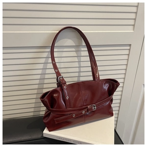 Close-up of deep red glossy PU tote bag with vintage silver buckles and hardware