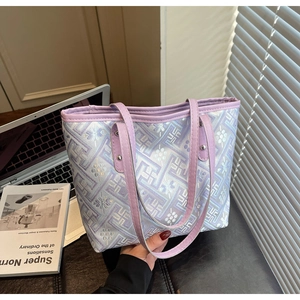 Close-up of purple plaid tote bag showing leather handles and textured fabric detail