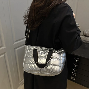 Silver quilted puffer tote bag with metallic finish and adjustable black shoulder strap