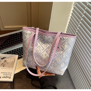 Close-up of purple jacquard tote bag with geometric patterns and leather handles
