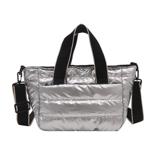 Chic silver quilted down tote bag with plush puffer texture and black adjustable strap