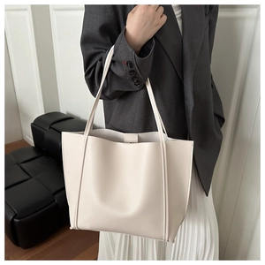 Large cream white tote bag worn with a gray blazer for a minimalist fashion look