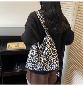 Black and white leopard print canvas tote bag with wide shoulder strap on model back view