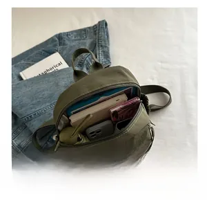 Detail showing inner capacity of army green nylon crossbody bag with daily essentials