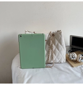 Cabas matelassé blanc avec chaîne et accessoires de bureau pour montrer la taille