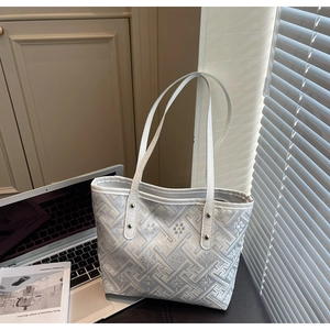 Close-up of retro geometric jacquard fabric and white handles on a tote bag detail