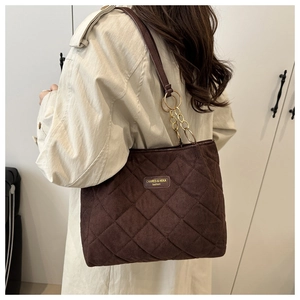 Brown quilted suede tote bag detail with gold metal rings and vintage textured finish