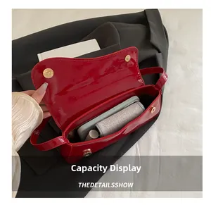 Interior view of red patent leather shoulder bag showing capacity for phone and cosmetics