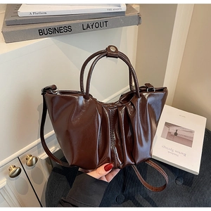 Detailansicht der dunkelbraunen Falten-Tasche mit glänzendem Leder und Silberbeschlägen