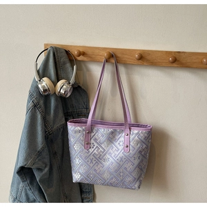 Detail of lavender plaid tote bag with embroidered patterns and leather handles